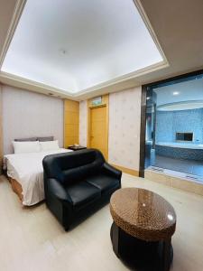 a bedroom with a bed and a chair and a table at Walker Motel 2 in Taipei
