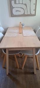 a wooden table with two chairs and a vase on it at Le Nid De Demolombe in Caen