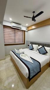 a bedroom with a large bed with a ceiling fan at TCS SUITES Chala Bypass Kannur in Thottada