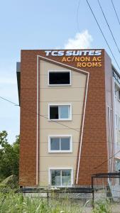 a building with a sign on the side of it at TCS SUITES Chala Bypass Kannur in Thottada