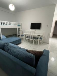 a living room with a blue couch and a tv at Hotel Infinity Shëngjin in Lezhë