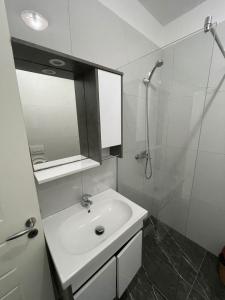 a white bathroom with a sink and a shower at Hotel Infinity Shëngjin in Lezhë +13 photos