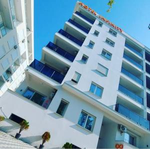 a white apartment building with windows on the side at Hotel Infinity Shëngjin in Lezhë