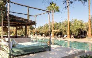 a resort with a swimming pool and a bed next to a resort at Domaine de Tameslohte in Tameslouht
