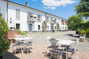 a patio with tables and chairs in front of a building at Agriturismo Albarossa in Nizza Monferrato