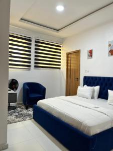 a bedroom with a blue bed and a blue chair at Waterfront 3BR Lekki Lagoon View in Maiyegun