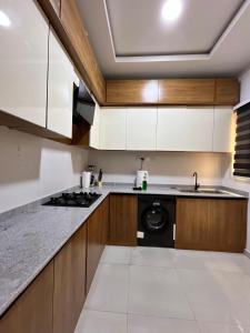 a kitchen with white cabinets and a black dishwasher at Waterfront 3BR Lekki Lagoon View in Maiyegun