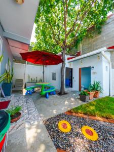 a patio with a picnic table and a red umbrella at Cozy apartment monica in San Pedro Sula