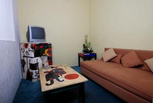 Hotel & Suites Galeria في موريليا: غرفة معيشة مع أريكة وطاولة