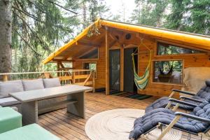 a log cabin with a hammock on a deck at Life House-Semkovo in Belitsa