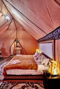 a bedroom with a bed in a tent at Palace desert camp in Merzouga +30 photos