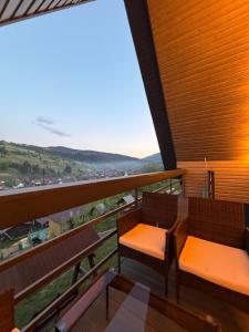 two benches on a balcony with a view at А-фрейм У Ґазди in Synevyrsʼka Polyana