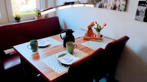 a dining room table with a tableablish at Geesthaus Geestland in Geestland +6 photos