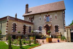 an old house with a garden in front of it at La Leugnyçoise in Leugny
