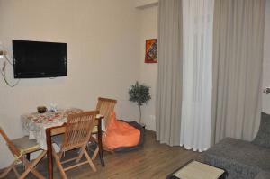 a living room with a table and a television on the wall at Ski Sun & Fun - next to iconic Marco Polo in Gudauri