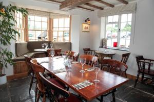 a dining room with tables and chairs and windows at The Kilcot Inn in Newent