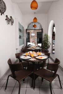une salle à manger avec une table, des chaises et de la nourriture. dans l'établissement Hotel & Suites Galeria, à Morelia