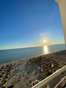 a view of a beach with the sun setting over the ocean at HRS Luxury Apartments in Durrës