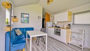 a small kitchen with a table and a blue couch at Domki Izerskie in Krobica +15 photos