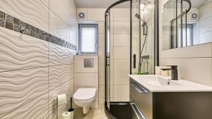 a bathroom with a toilet and a sink and a shower at Domki Izerskie in Krobica
