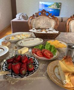 a table with plates of food and fruits and vegetables at Stariy Marokand in Samarkand