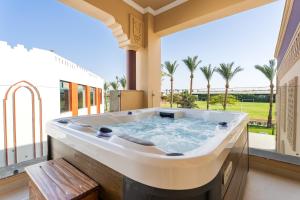 a jacuzzi tub on a balcony with palm trees at Sunrise Mamlouk Palace Resort in Hurghada
