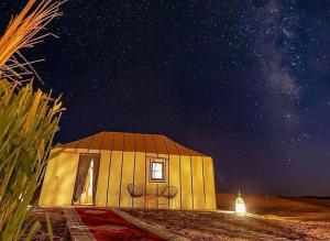 a small house with a starry sky at night at Palace desert camp in Merzouga