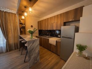 a kitchen with a refrigerator and a table with flowers at Villa Tba near Borjomi, Tsemi and Sadgeri in Tsemi