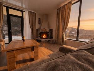 a living room with a couch and a fireplace at Villa Tba near Borjomi, Tsemi and Sadgeri in Tsemi