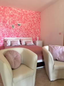 a pink bedroom with a bed and a couch at Casa vacanze Alfano in Ascea