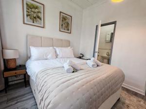 a bedroom with a large white bed with two stuffed animals on it at The Forest- Greenwood in Cambridge