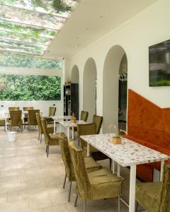 a restaurant with tables and chairs and a large window at Villa Maria Cristina in Caserta
