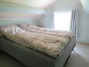 a bed with a blanket on it in a room at Higravstinden Basecamp - Lofoten in Laupstad