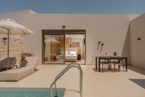 a living room with a table and a pool at Increteblue Suites in Plakias