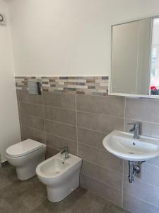 a bathroom with a sink and a toilet and a mirror at Domus Palatium in Palazzolo Acreide