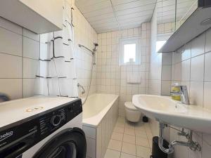 a bathroom with a sink and a washing machine in it at LEU111 komfortable Monteurwohnung in Leuchtenberg