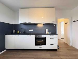 a kitchen with white cabinets and a black counter top at LEU111 komfortable Monteurwohnung in Leuchtenberg