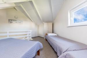 a bedroom with two beds and a window at Apartamentai Upė in Šventoji