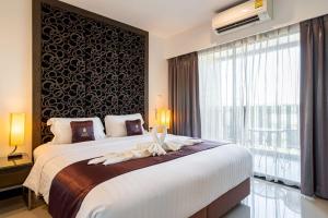 a bedroom with a large bed with a large window at Lani Chiang Mai Hotel in Chiang Mai