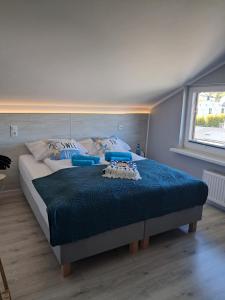 a bedroom with a large bed with a blue comforter at Przystań Pod Wieżą in Władysławowo