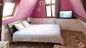 a bedroom with a bed in a room with purple walls at Chez Esmara Et Philippe Fourche in Brussels