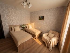 a small room with two beds and a chair at Villa Tba near Borjomi, Tsemi and Sadgeri in Tsemi