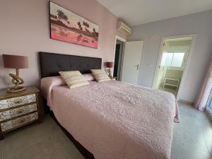 a bedroom with a large bed with a pink bedspread at HondaMar in Playa Honda +14 photos