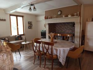 a kitchen and dining room with a table and chairs at Les Roses d Antan - 2 gîtes in Néville