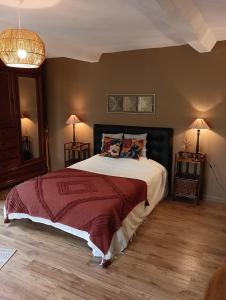 a bedroom with a large bed and two lamps at Les Roses d Antan - 2 gîtes in Néville