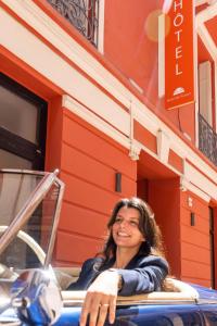 a woman sitting in a chair in front of a building at Hôtel de France in Monte Carlo