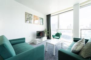 a living room with green furniture and a large window at THE OLIVE SUITE At The Rotunda in Birmingham