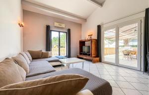 a living room with a couch and a tv at Maison Proche Uzès in Vers Pont du Gard