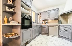 a kitchen with stainless steel appliances and white cabinets at Maison Proche Uzès in Vers Pont du Gard