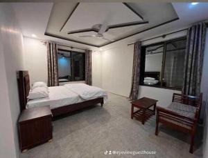 a bedroom with a bed and a table and a window at EYE VIEW hotel skardu in Skardu